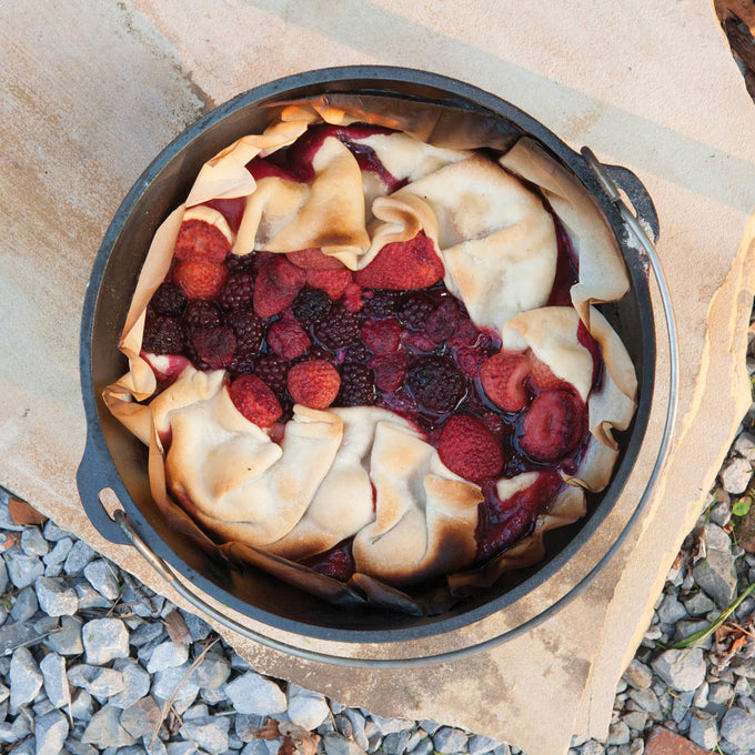 Handcrafted Lodge cast iron camp Dutch oven baking a mixed berry dessert with folded crust outdoors, featured in Farm, Garden & Tool, Camping, Cast Iron, USA Made, Best Sellers, and Promo Eligible collections.