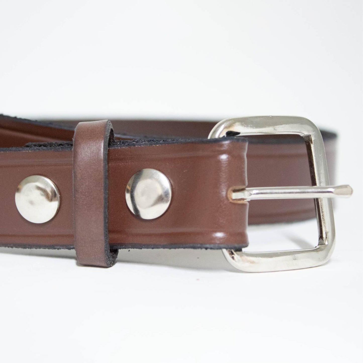Close-up of a handcrafted Amish-made brown leather belt with polished chrome buckle and snap details, part of Clothing and Accessories, USA Made, Amish Made, and Best Sellers collections.
