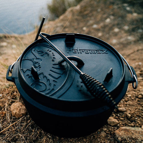 Black cast iron Dutch oven with legs and an embossed lid featuring a raised sun design and sturdy bail handle, perfect for outdoor and indoor cooking in Kitchen & Food, Cookware, Cast Iron, Best Sellers, Promo Eligible collections.