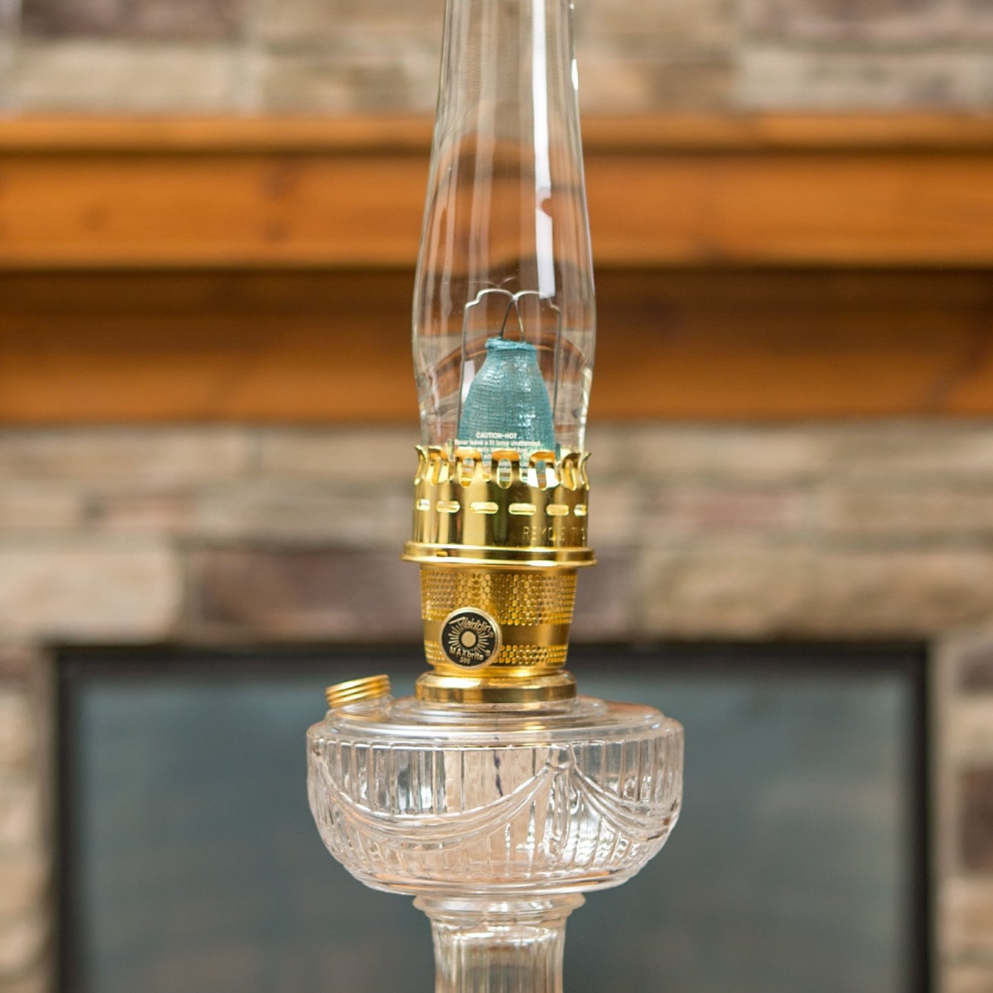Glass oil lamp with clear base, brass burner, and bright blue flame mantle, part of Lamps & Lighting, Parts and Accessories, Wicks and Mantles, Lamp Burners and Collars, Best Sellers, and Promo Eligible collections.
