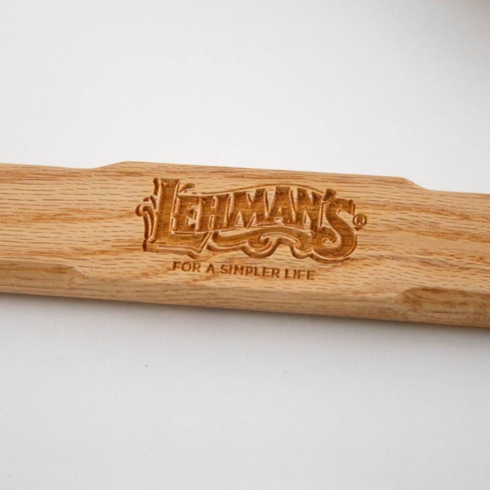 Close-up of a wooden handle engraved with Lehman’s logo and tagline, showcasing handcrafted quality for tools in farm, garden, and wood cutting collections.