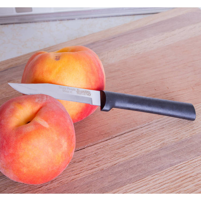 Handcrafted serrated paring knife with finely toothed blade and smooth black handle, made in USA, shown with fresh peaches on wooden cutting board, ideal for food prep and farm, garden & tool collections.