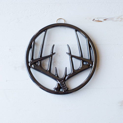 Round enamel trivet featuring a glossy antler design with built-in hanger and rubber feet to protect surfaces, ideal for Kitchen & Food, Dinnerware, Storage and Serving, Best Sellers, and Promo Eligible collections.