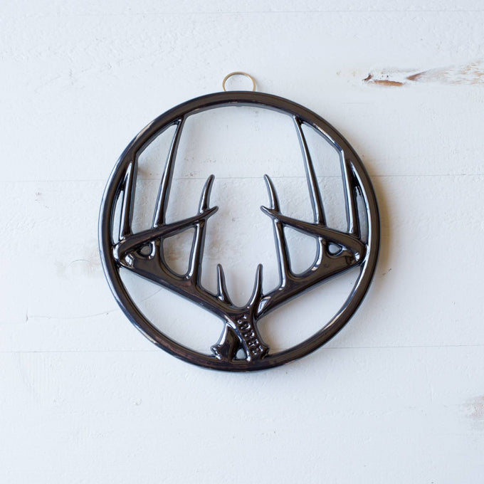 Round enamel trivet featuring a glossy antler design with built-in hanger and rubber feet to protect surfaces, ideal for Kitchen & Food, Dinnerware, Storage and Serving, Best Sellers, and Promo Eligible collections.