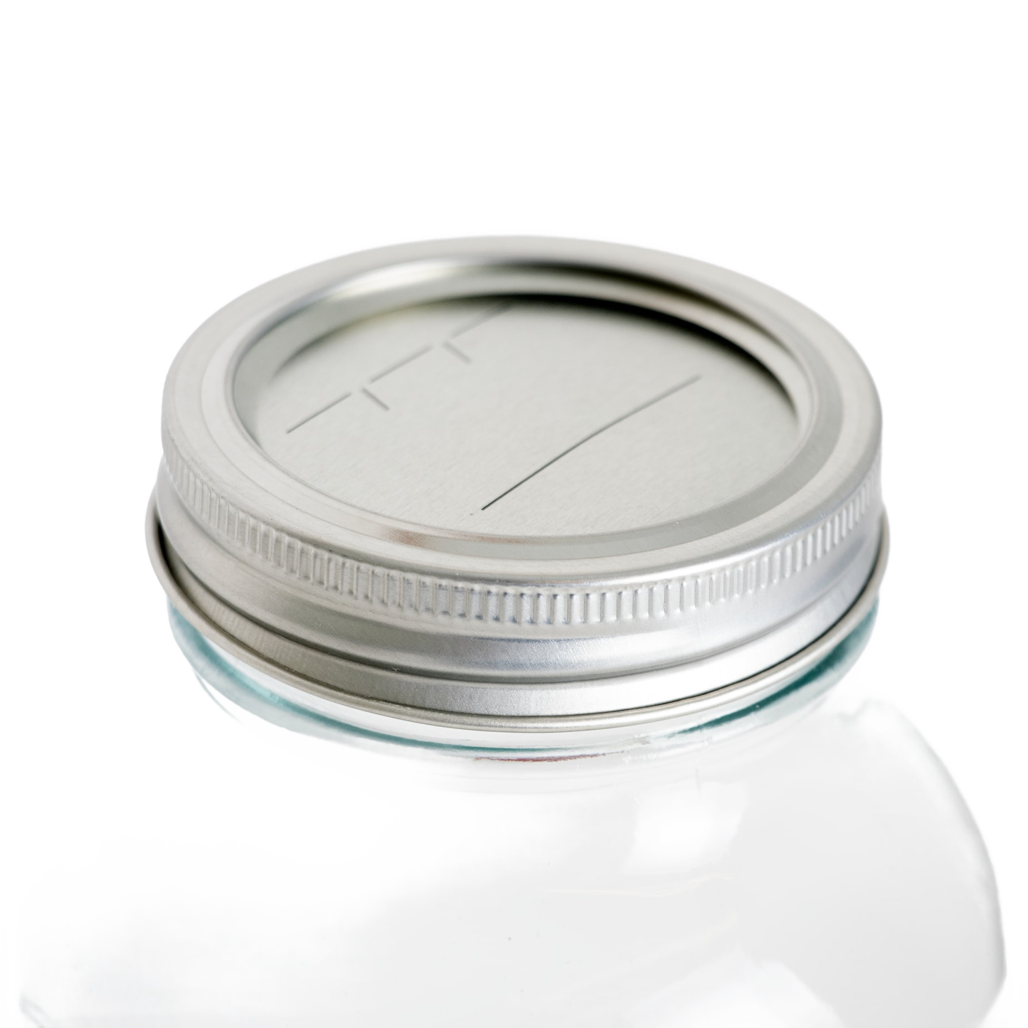 Silver metal regular-mouth canning lid and band with BPA-free sealing compound on clear glass jar, suitable for Kitchen & Food, Food Preservation, and Canning collections.