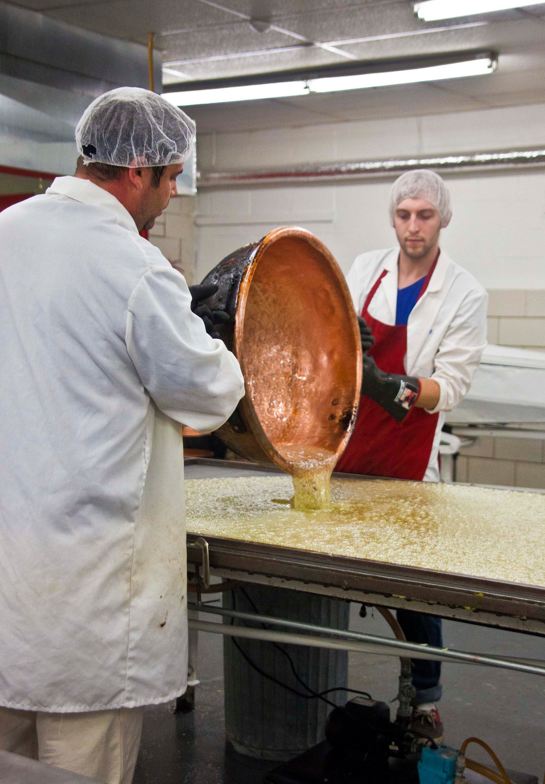 Owner Greg Dauphin (left) and candymaker Shawn Freeder pour the Sugar Puff base onto the cooling table.