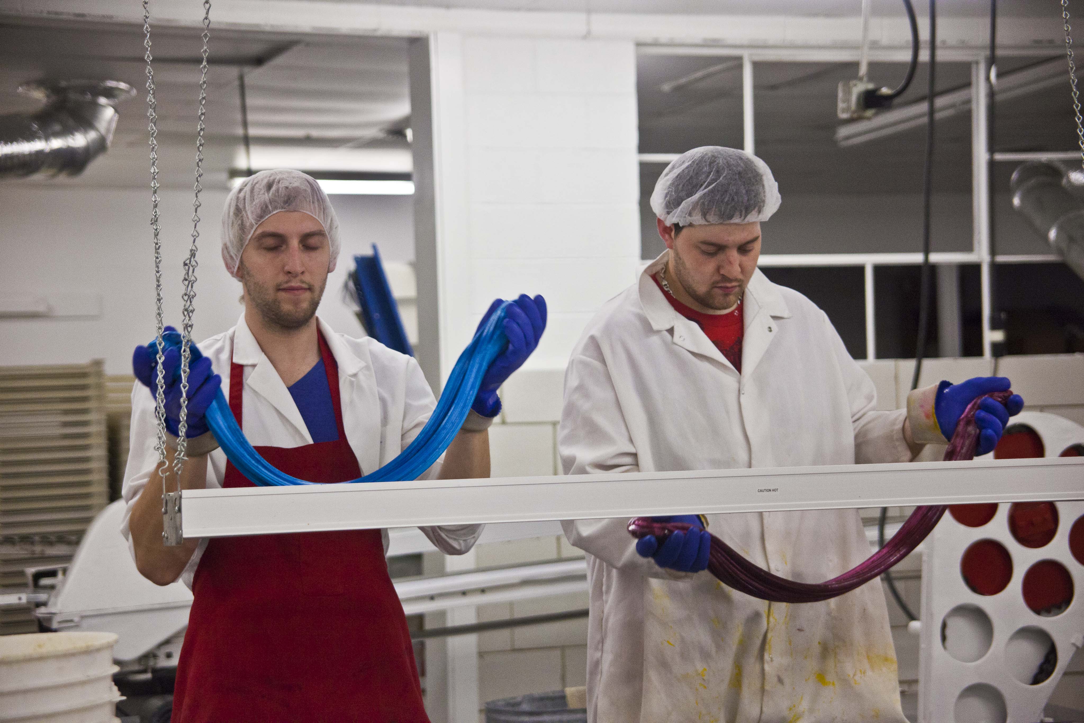 While the puller/mixer is working, Shawn and Paul hand pull pink and blue stripes.