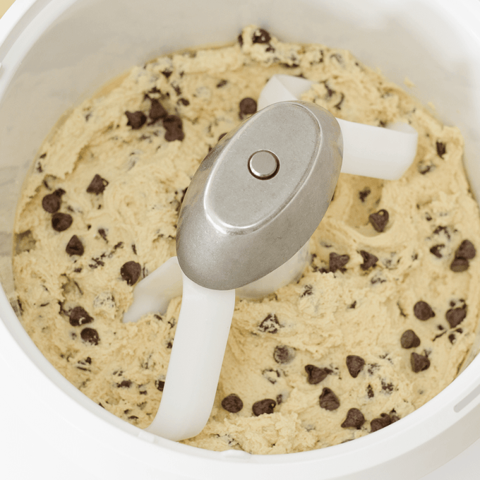 White cookie paddle attachment mixing chocolate chip cookie dough in a Bosch or NutriMill mixer bowl, designed for thick batters in Kitchen & Food and Baking Supplies collections.