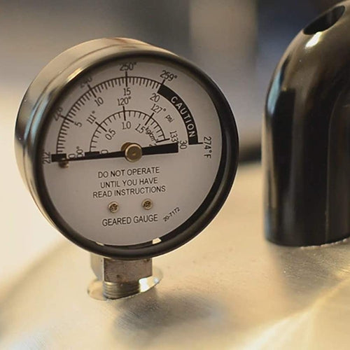 Close-up of a geared pressure gauge marked with temperature and pressure readings, warning not to operate before reading instructions, featured in Food Preservation, Canning, USA Made, and Kitchen & Food collections.