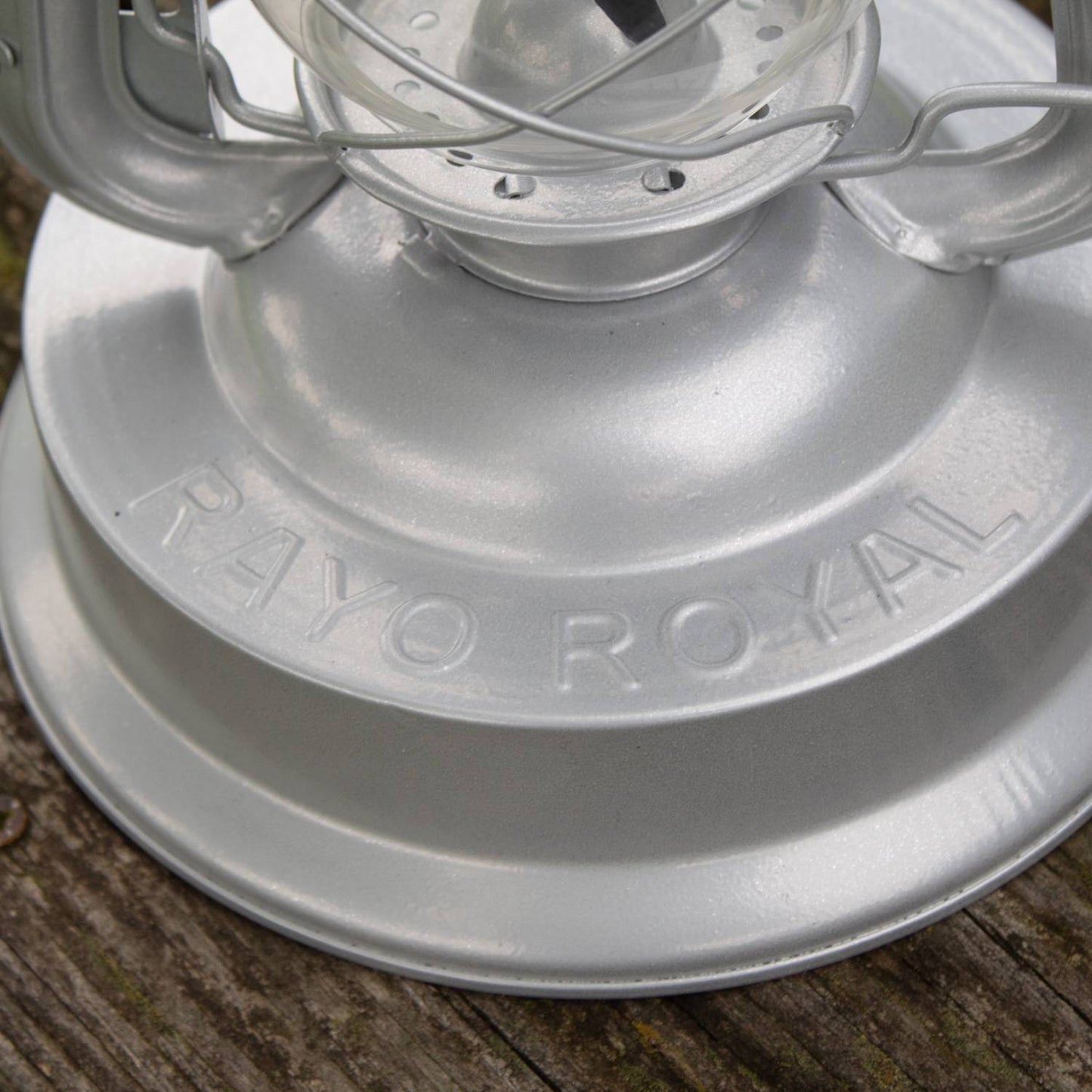 Close-up of a handcrafted silver metal Rayo Royal Lantern’s base with embossed name, showcasing durable construction for farm, garden, camping, and emergency use.