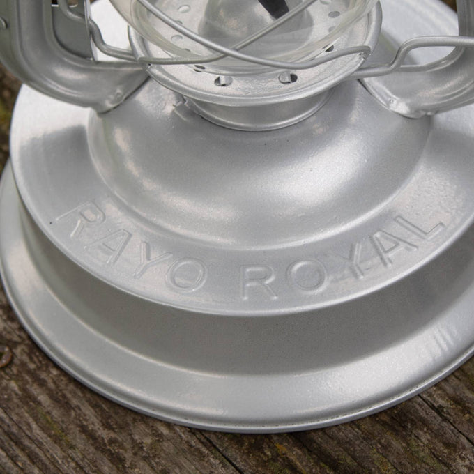 Close-up of a handcrafted silver metal Rayo Royal Lantern’s base with embossed name, showcasing durable construction for farm, garden, camping, and emergency use.