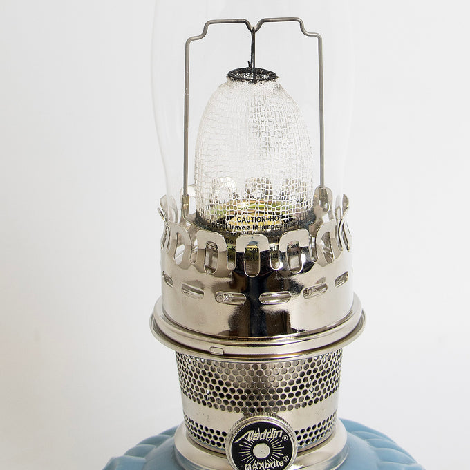 Close-up view of a handcrafted burner with perforated metal design and clear textured glass chimney on a limited edition blue glass base oil lamp, featured in Lamps & Lighting, Oil Lamps, Table Lamps, Best Sellers, and Promo Eligible collections.