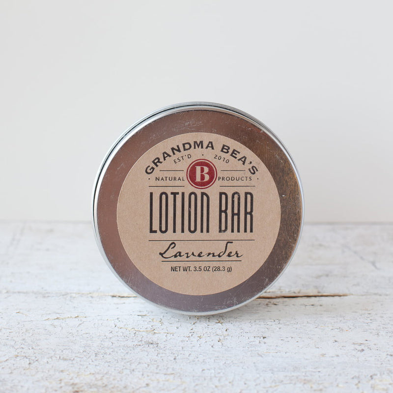Round all-natural lotion bar tin with lavender scent, handcrafted in the USA, nourishing skin with oils, vitamin E, and beeswax, featured in Health & Wellness, Balms, Creams and Lotions, Grooming and Personal Hygiene, USA Made, Best Sellers, and Promo Eligible collections.