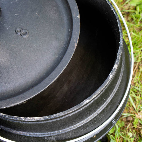 Close-up of a handcrafted cast iron kettle lid partially open, showing the sturdy round body with textured edges, ideal for outdoor cooking in Farm, Garden & Tool, Camping, Best Sellers, and Promo Eligible collections.