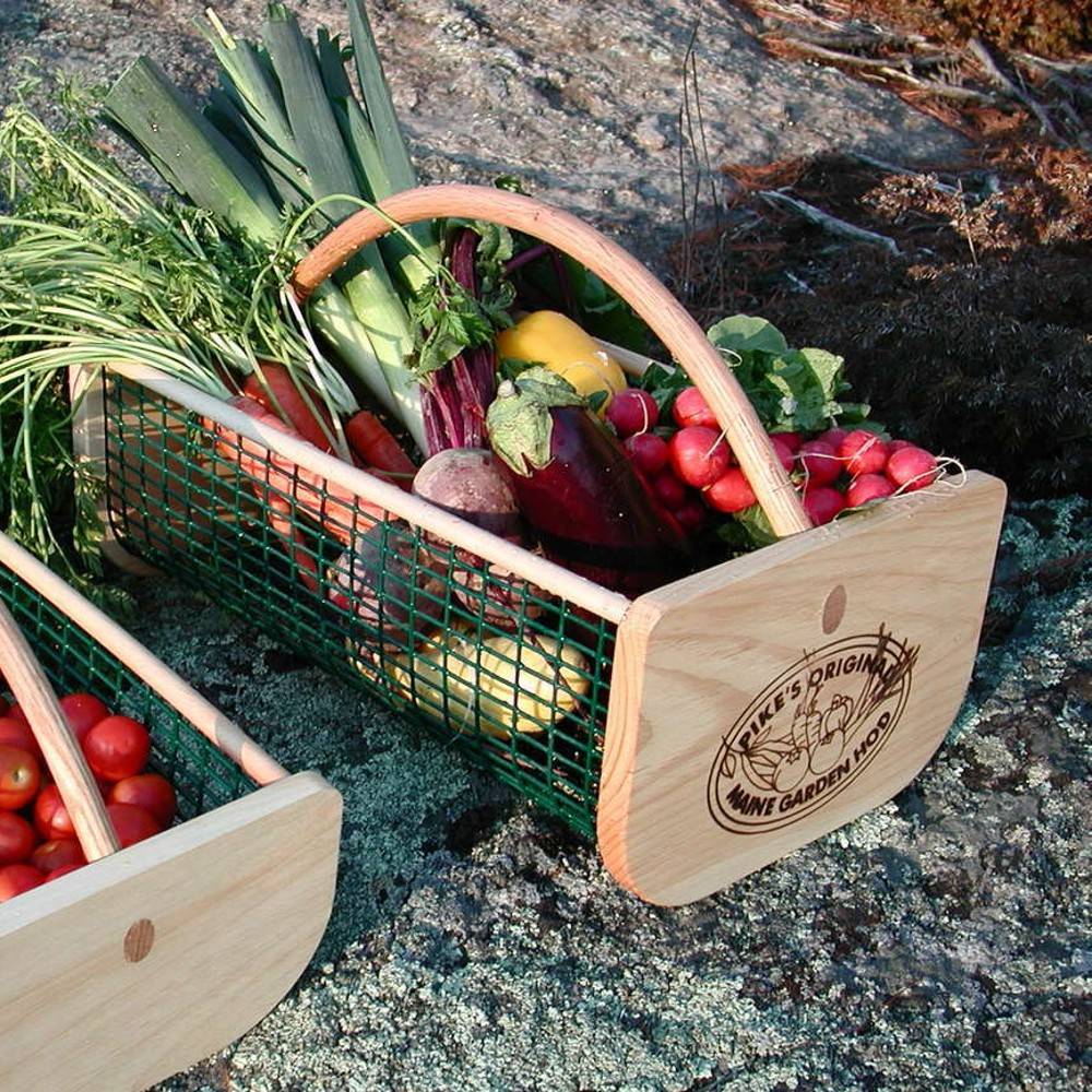 Handcrafted Maine Garden Hod with smooth wooden ends featuring engraved logo and curved handle, green wire mesh body filled with fresh garden vegetables, part of Farm, Garden & Tool, Garden Accessories, USA Made, Best Sellers, and Promo Eligible collections.