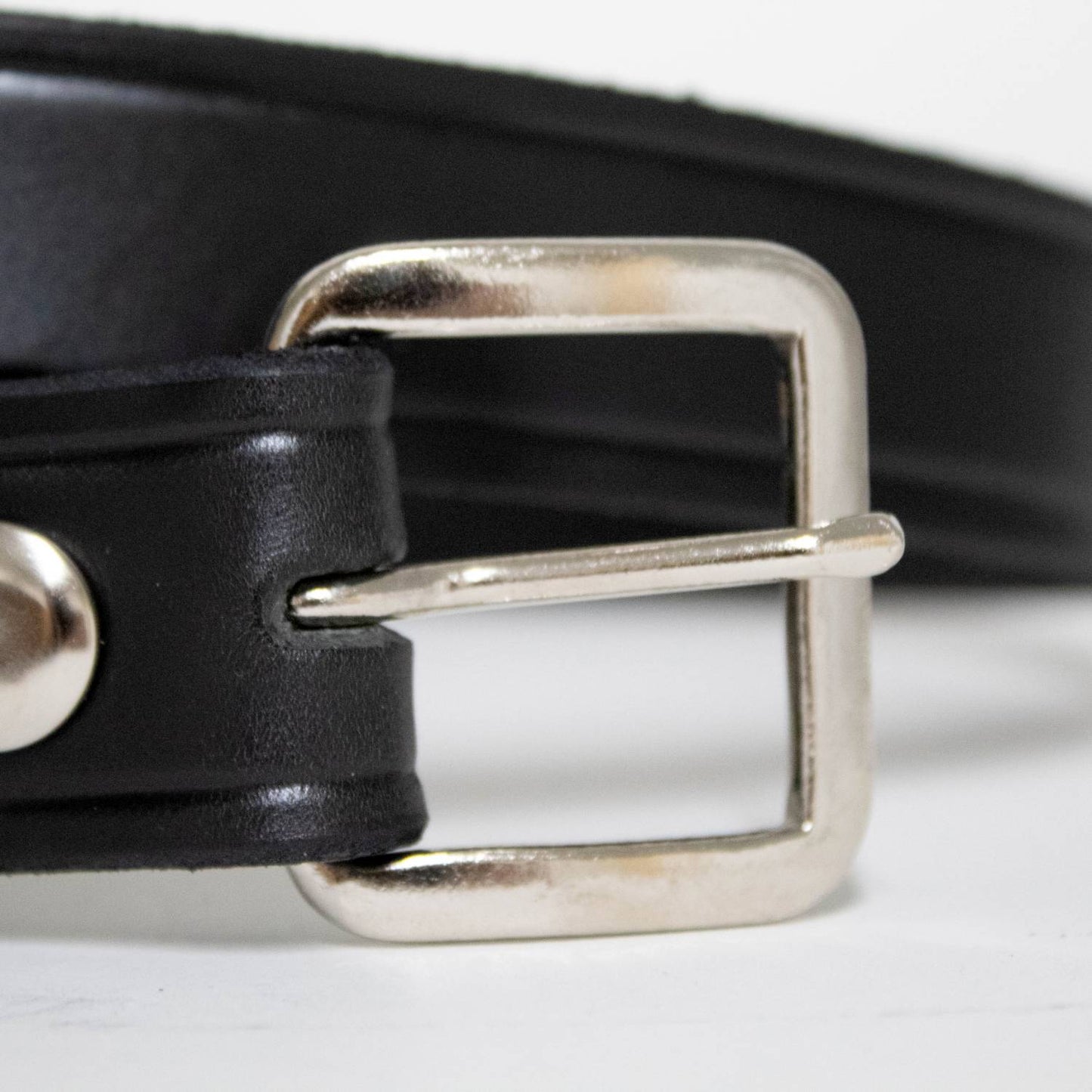 Close-up of a handcrafted Amish made black genuine cowhide leather belt with polished chrome square buckle and snap fasteners, featured in Health & Wellness, USA Made, and Best Sellers collections.
