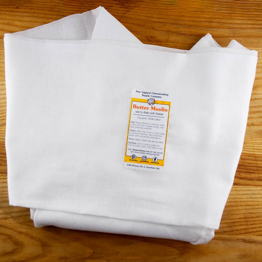 Piece of heavy-duty, tightly woven 100% cotton butter muslin used for draining soft cheeses, shown folded on a wooden surface, ideal for Kitchen & Food and DIY Cheese collections.