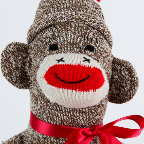 Hand-sewn vintage-inspired sock monkey toy made in USA from classic red and white heel socks, featuring a cheerful knitted face and red ribbon bow, perfect for indoor play and children's toys.