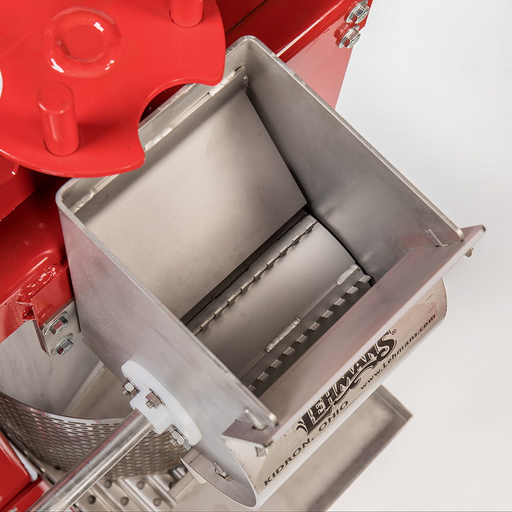 Close-up of a durable stainless steel fruit crushing mechanism with sharp blades inside a red-framed Lehman’s cider press, designed for orchard and farm use, USA made and featured in Farm, Garden & Tool and Apple Harvest Supplies collections.