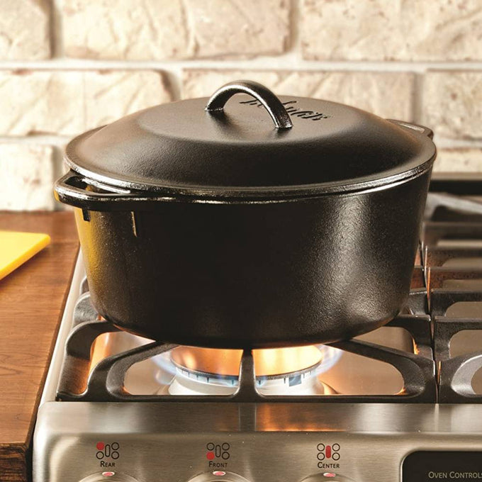 Handcrafted black cast iron Dutch oven with matching lid heating on a gas stove, known for durability and excellent heat retention; ideal for Kitchen & Food, Cookware, Cast Iron, USA Made, Best Sellers, Promo Eligible.
