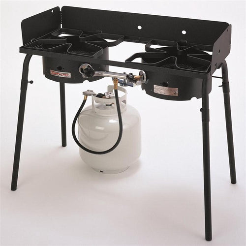 Black double burner outdoor cooker with removable legs, adjustable propane gas burners connected to a white LP tank, ideal for camping, emergency supplies, and farm use.