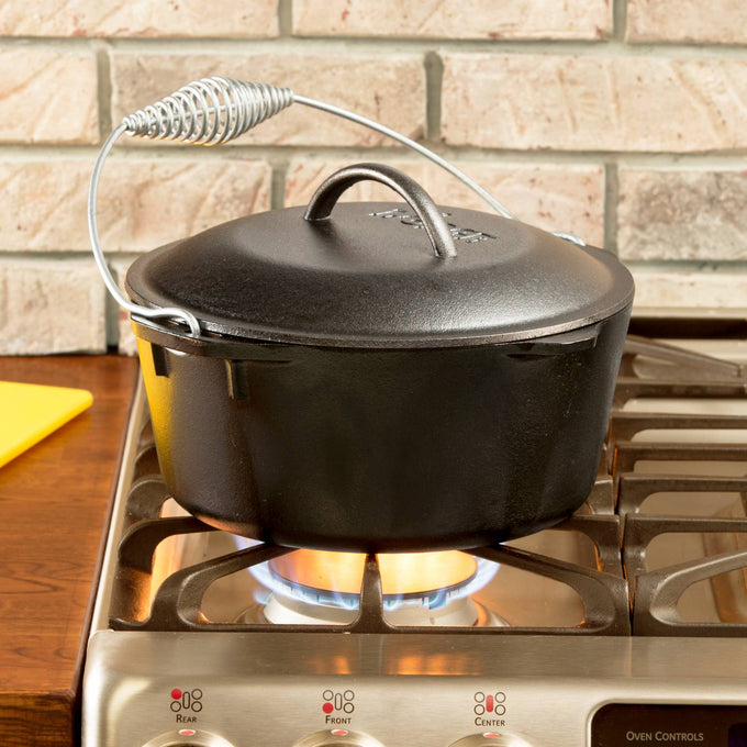 Pre-seasoned Lodge Logic cast iron Dutch oven with spiral bail handle and self-basting lid, heating on stovetop burner, ideal for Kitchen & Food, Cookware, Cast Iron, USA Made, Best Sellers, and Promo Eligible collections.