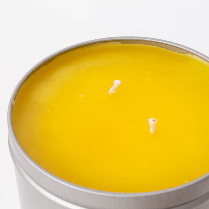 Hand-poured Amish-made citronella candle with bright yellow wax in a lightweight metal tin, designed for outdoor use in camping, pest control, and garden lighting collections.