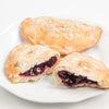 Three handcrafted Amish-style blueberry fry pies on a white plate, one whole and two cut open to reveal thick, juicy blueberry filling, part of Kitchen & Food, Snacks and Sweets, USA Made, and Best Sellers collections.