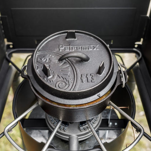 Black cast iron Dutch oven with raised legs and an embossed lid featuring a decorative sun pattern and handle, crafted for durable cooking in Kitchen & Food, Cookware, Cast Iron, Best Sellers, and Promo Eligible collections.