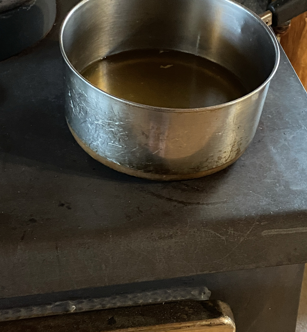 Warming up bone broth on wood stove