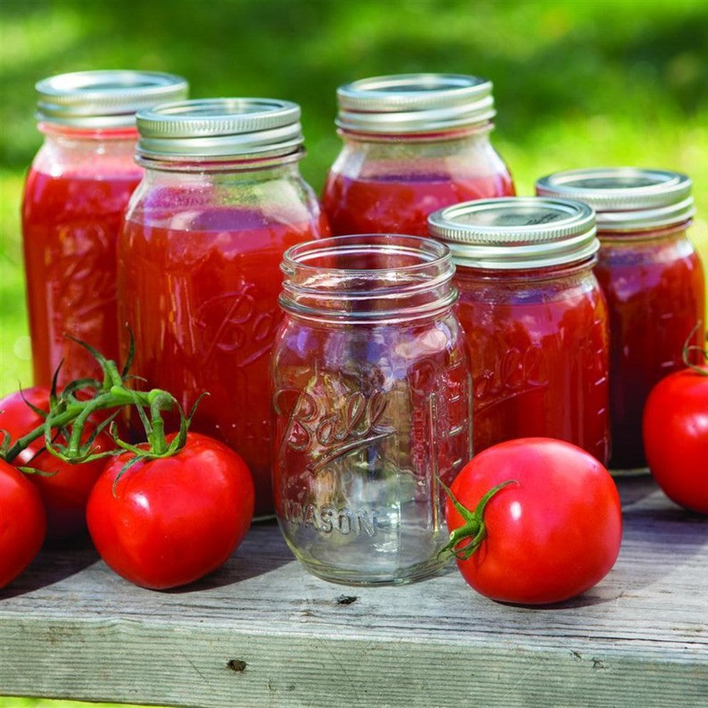 Clear glass regular-mouth canning jars with metal lids, some filled with homemade tomato sauce, surrounded by fresh tomatoes on a wooden surface, highlighting Kitchen & Food, Food Preservation, Canning, USA Made, and Best Sellers collections.