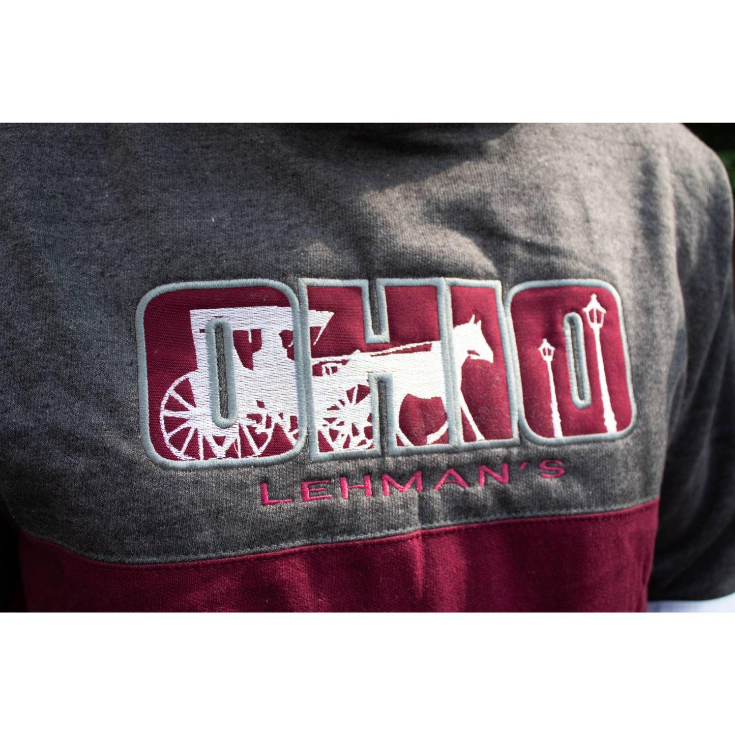 Close-up of a handcrafted fleece pullover featuring a unique Ohio design with embroidered horse, carriage, and lamppost motifs, part of Health & Wellness and Clothing collections.