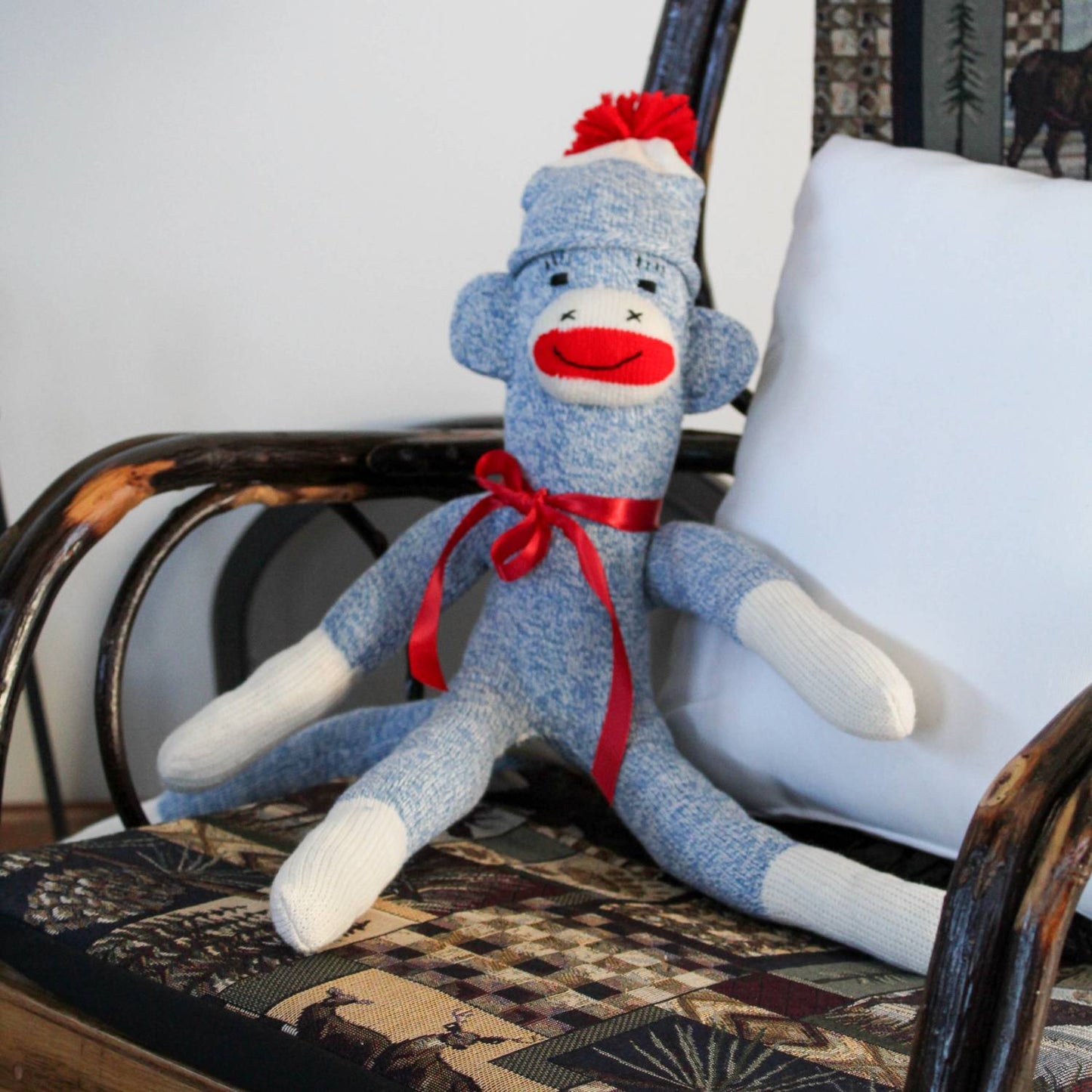 Handcrafted blue and white sock monkey with red ribbon bow and pom-pom hat, made in USA, featured in Toys, Books & Games, Children's Toys, Indoor Play, Best Sellers, and Promo Eligible collections.