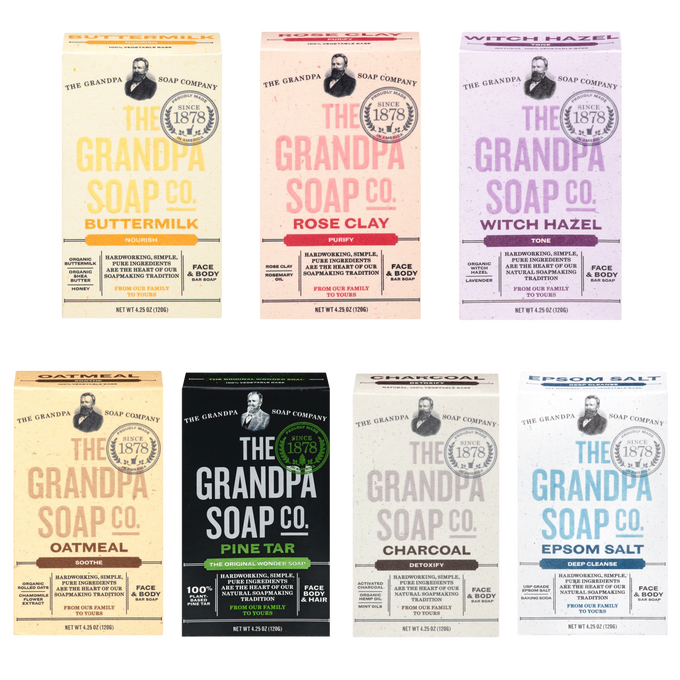 Arrangement of handcrafted soaps in varieties including buttermilk, rose clay, witch hazel, oatmeal, pine tar, charcoal, and epsom salt, highlighting natural US-made grooming and wellness products.