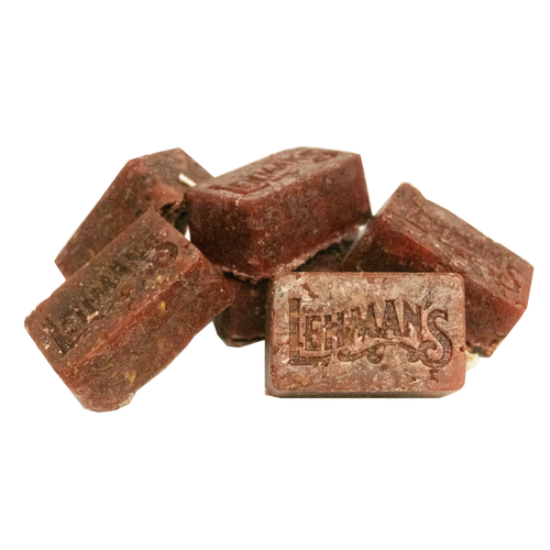 Pile of handcrafted reddish-brown fire starter blocks stamped with Lehman’s logo, made in the USA from natural reclaimed wax and sawdust, ideal for stoves, camping, and hearth accessories.