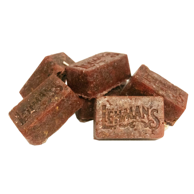 Pile of handcrafted reddish-brown fire starter blocks stamped with Lehman’s logo, made in the USA from natural reclaimed wax and sawdust, ideal for stoves, camping, and hearth accessories.