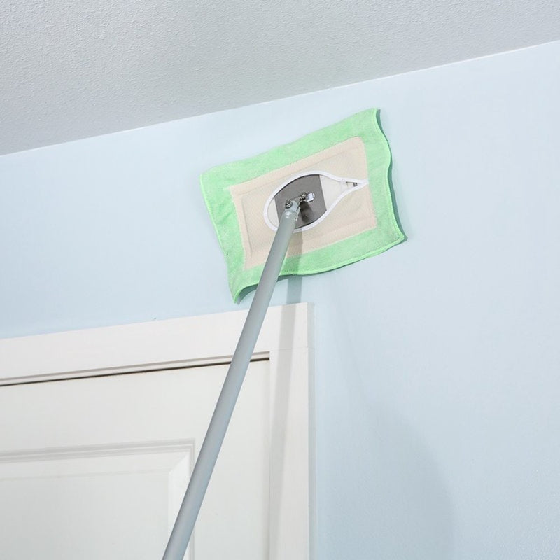 Long-handled cleaning mop with a green washable flat head reaching high on a light blue wall above a white door, showcasing a handcrafted Amish-made cleaning tool from USA collections.