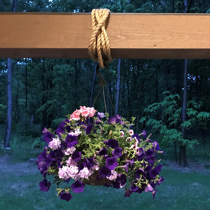 Natural fiber hemp rope looped securely around a wooden beam, suspending a hanging basket of vibrant purple and pink flowers, ideal for Farm, Garden & Tool and Farm Tools collections.