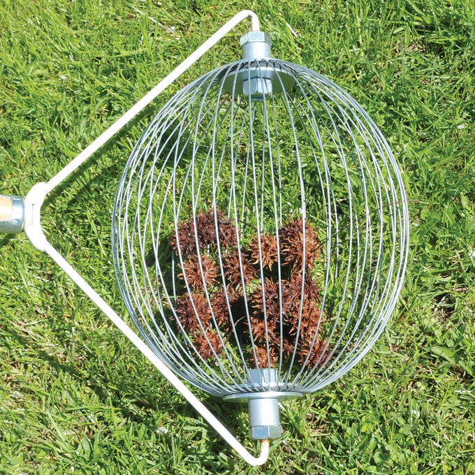 Handcrafted wire nut collector with wooden handle gathering spiky seed pods on green grass, designed for effortless yard cleanup with no bending; featured in Farm, Garden & Tool, Lawncare, Best Sellers, Promo Eligible collections.