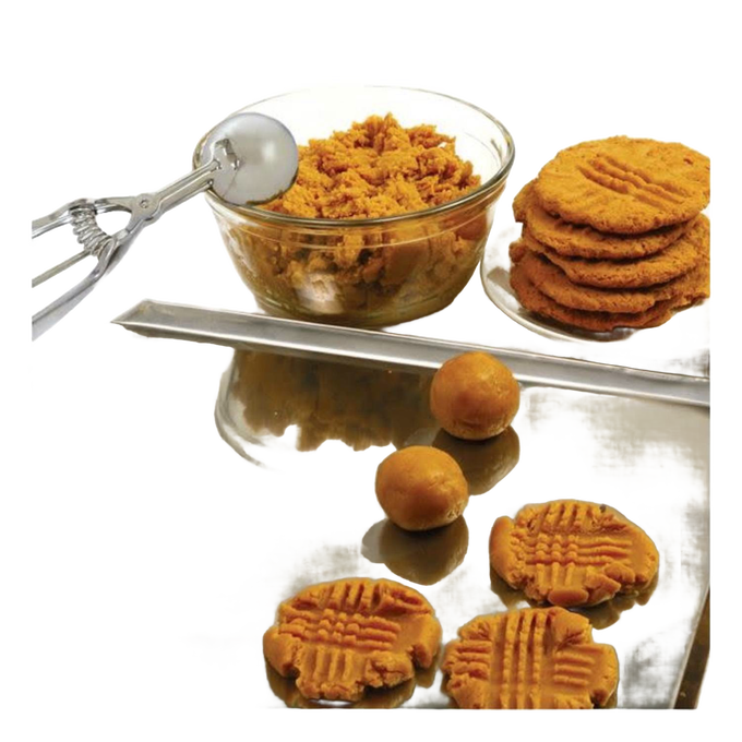 Metal scoop with spring handle next to clear glass bowl filled with cookie dough and a stack of freshly pressed peanut butter cookies on a reflective surface, handcrafted for Kitchen & Food, Cookware, Baking Supplies, and Best Sellers collections.