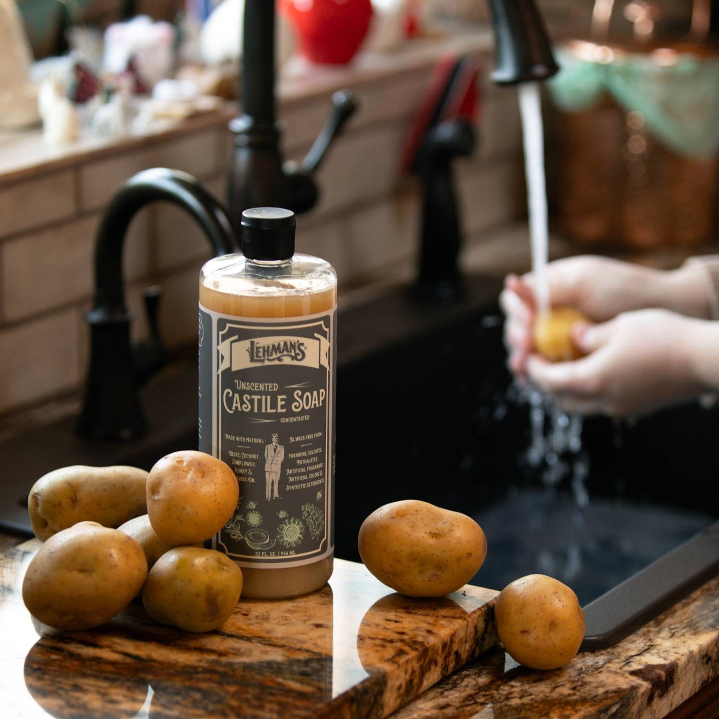 Amber bottle of Lehman's Castile concentrated liquid soap with unscented natural formula displayed on a kitchen counter beside fresh potatoes, promoting USA made health and grooming products.