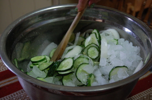 Cukes, ingredients iced in steel bowl.