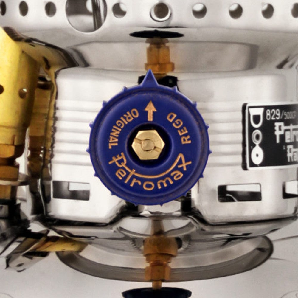 Close-up of a blue control valve on a polished metal kerosene pressure lamp showcasing precise engineering and durable materials for reliable outdoor, camping, and emergency lighting.