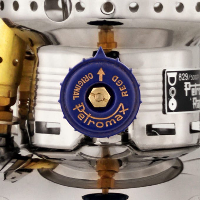 Close-up of a blue control valve on a polished metal kerosene pressure lamp showcasing precise engineering and durable materials for reliable outdoor, camping, and emergency lighting.