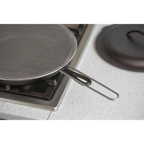 Stainless steel splatter screen resting on a stovetop burner with a long handle, designed to protect kitchen surfaces during cooking, featured in Kitchen & Food, Kitchen Gadgets, and Best Sellers collections.
