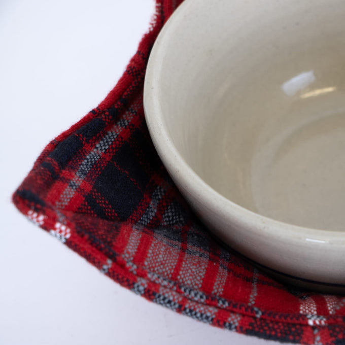 Close-up of a handcrafted red and black plaid cotton bowl cozy protecting fingers and surfaces, ideal for Kitchen & Food, Kitchen Textiles, Storage and Serving, and Best Sellers collections.