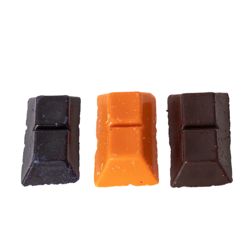 Three handcrafted soy wax dye chips in dark brown, bright orange, and deep red colors, designed for use in candle making supplies collections.