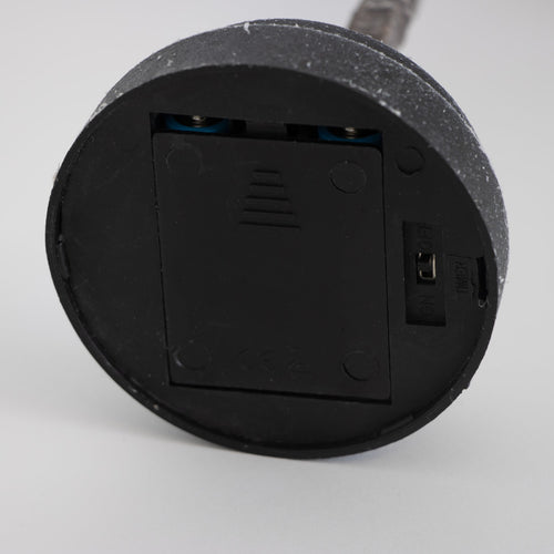 Close-up of a black round battery compartment with a slide cover and on/off switch, part of a handcrafted lighted holiday tree for Home & Decor, Holiday Decor, Best Sellers, and Promo Eligible collections.