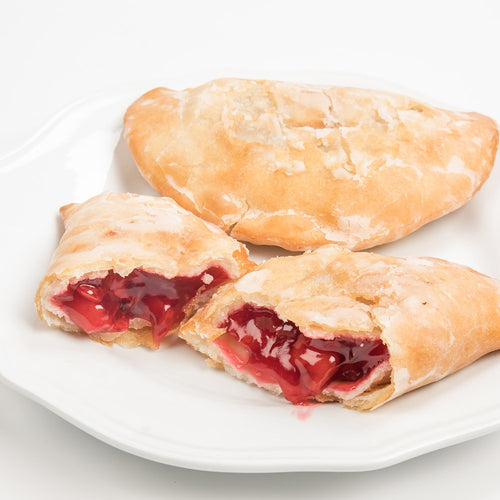 Handcrafted Amish-style fry pies with a golden crust and sweet cherry filling on a white plate, perfect for Kitchen & Food, Snacks and Sweets, Holiday Hosting, USA Made, and Best Sellers collections.