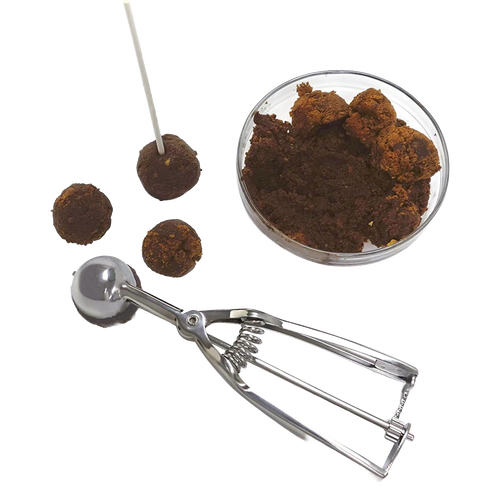 Handcrafted metal scoop with spring release mechanism next to a glass bowl of cookie dough and four uniform dough balls on a white background, ideal for Kitchen & Food, Cookware, Baking Supplies, and Best Sellers collections.